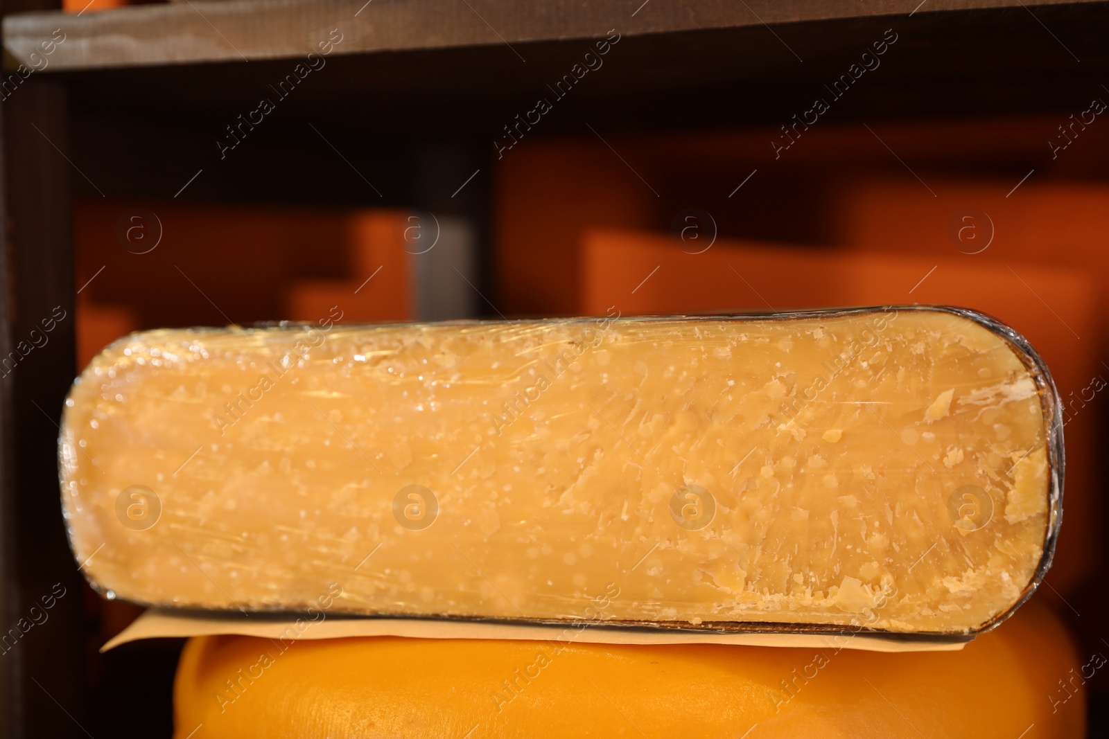 Photo of Delicious cheese in store, closeup. Dairy product