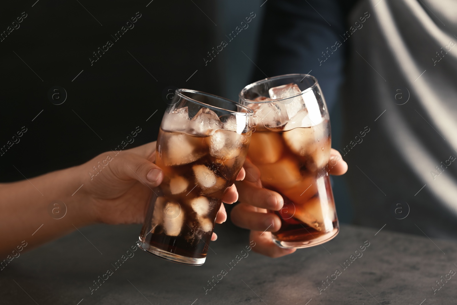 Photo of Friends with glasses of tasty refreshing cola at table, closeup view