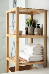 Photo of Shelving unit with toiletries in bathroom interior