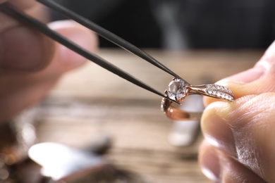 Male jeweler examining diamond ring in workshop, closeup view