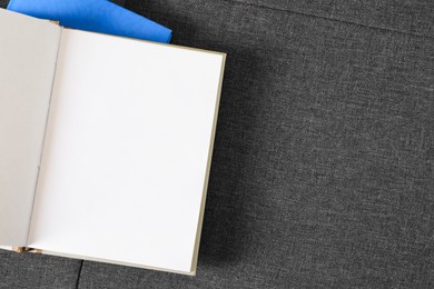 Photo of Hardcover books on grey fabric, top view. Space for text