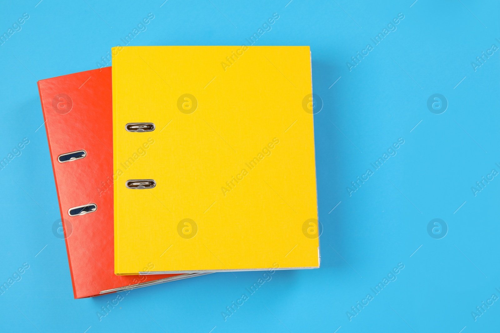 Photo of Office folders on light blue background, flat lay. Space for text