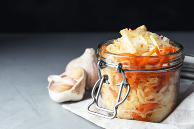 Tasty fermented cabbage with carrot on light grey table, closeup