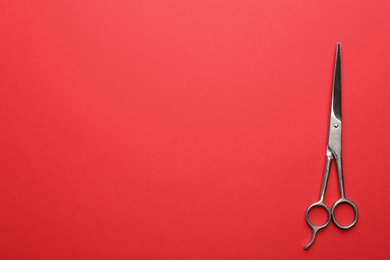 Hairdresser's scissors on color background, top view. Space for text