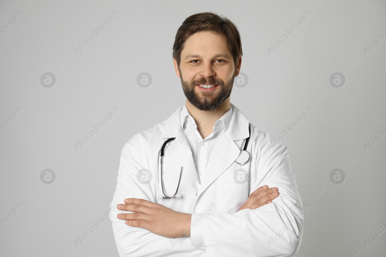 Photo of Doctor or medical assistant (male nurse) with stethoscope on light grey background