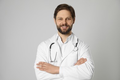 Photo of Doctor or medical assistant (male nurse) with stethoscope on light grey background