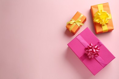 Bright gift boxes on pink background, flat lay. Space for text