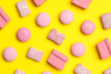 Pink bubble gums on yellow background, flat lay