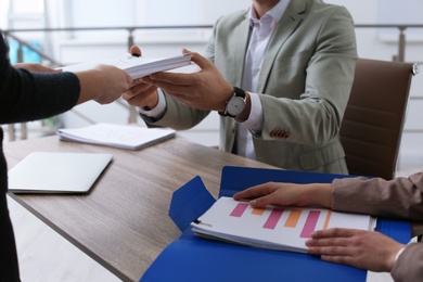 Office employees working with documents at table indoors