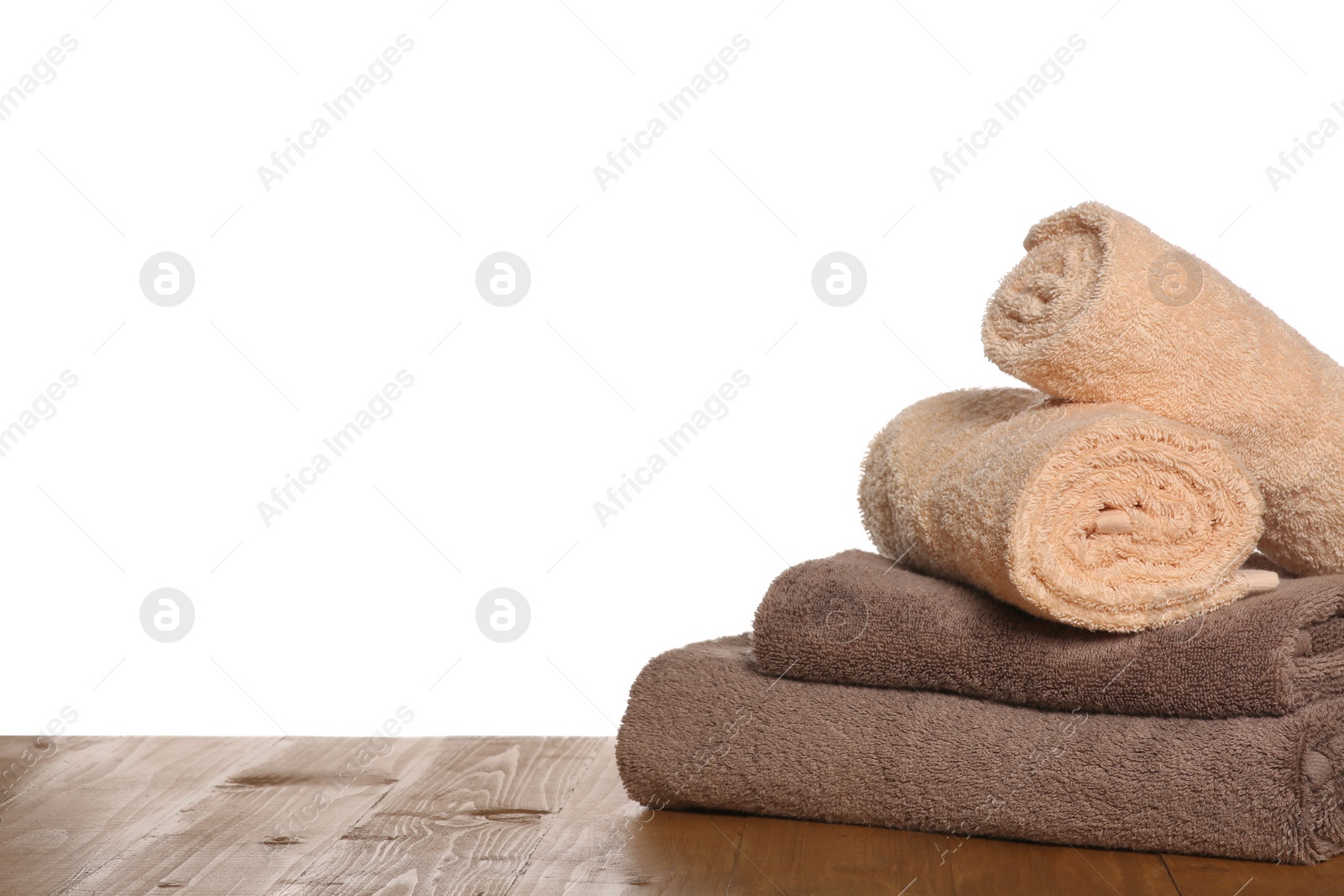 Photo of Soft colorful terry towels on wooden table against white background, space for text