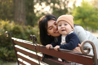 Photo of Happy mother and her baby on bench in park