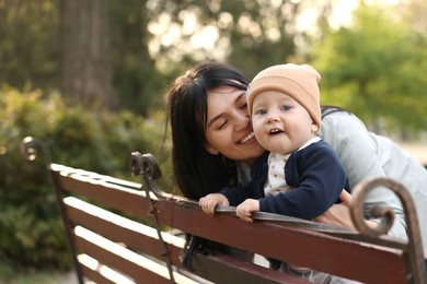 Happy mother and her baby on bench in park