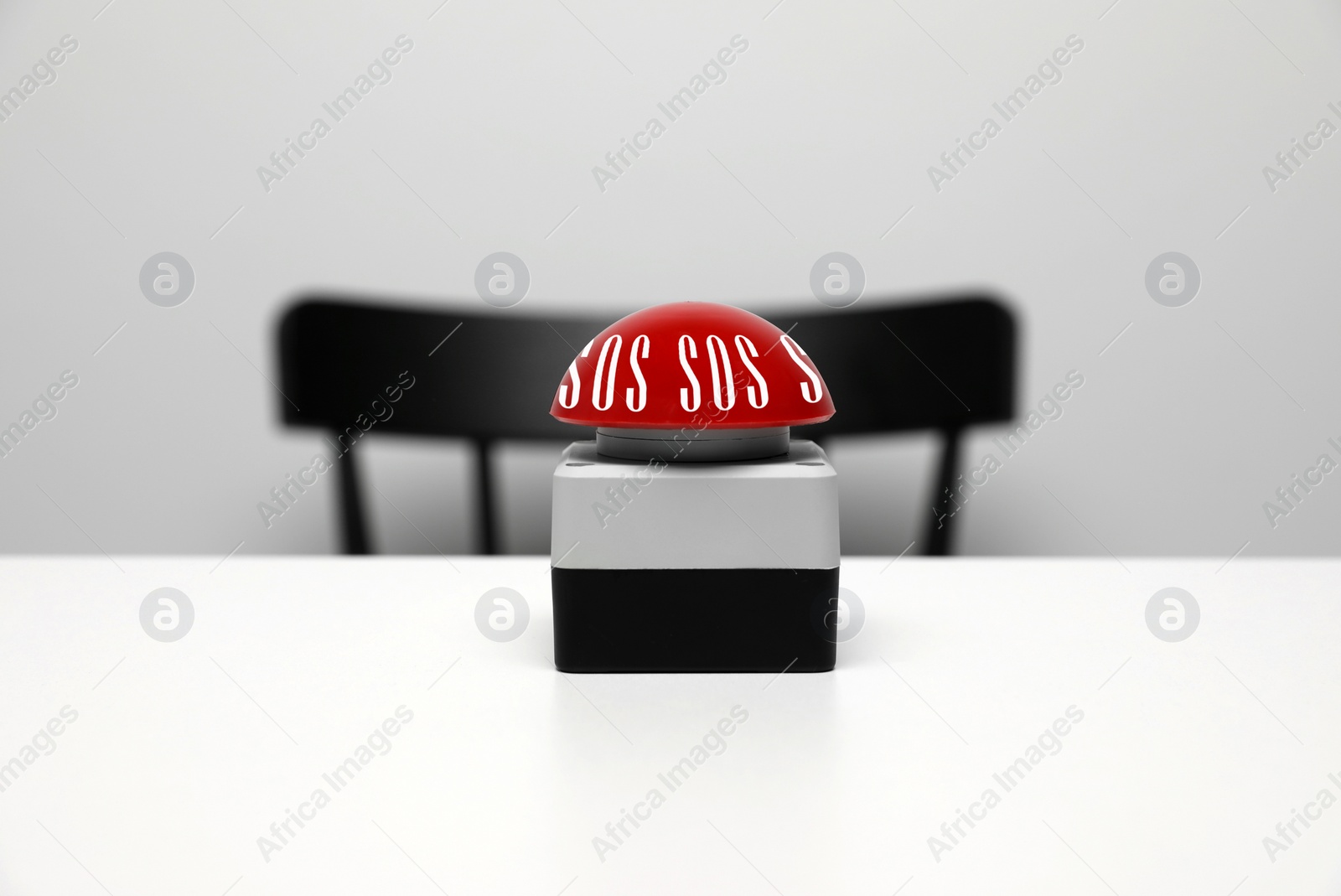 Image of Red SOS button on white table background. Space for text