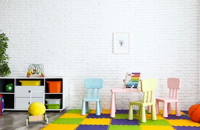 Stylish playroom interior with toys and modern furniture