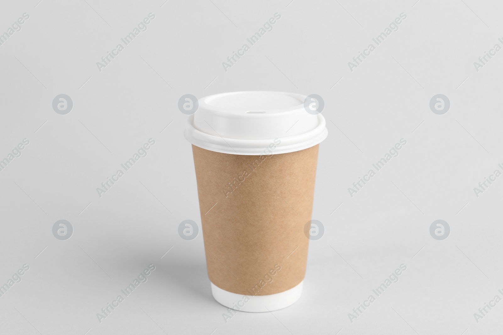 Photo of Paper cup with plastic lid on light background. Coffee to go