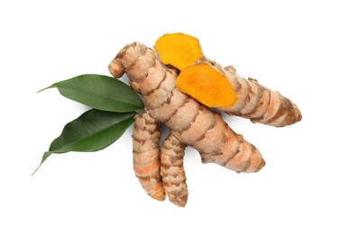 Photo of Fresh turmeric roots and green leaves isolated on white, top view