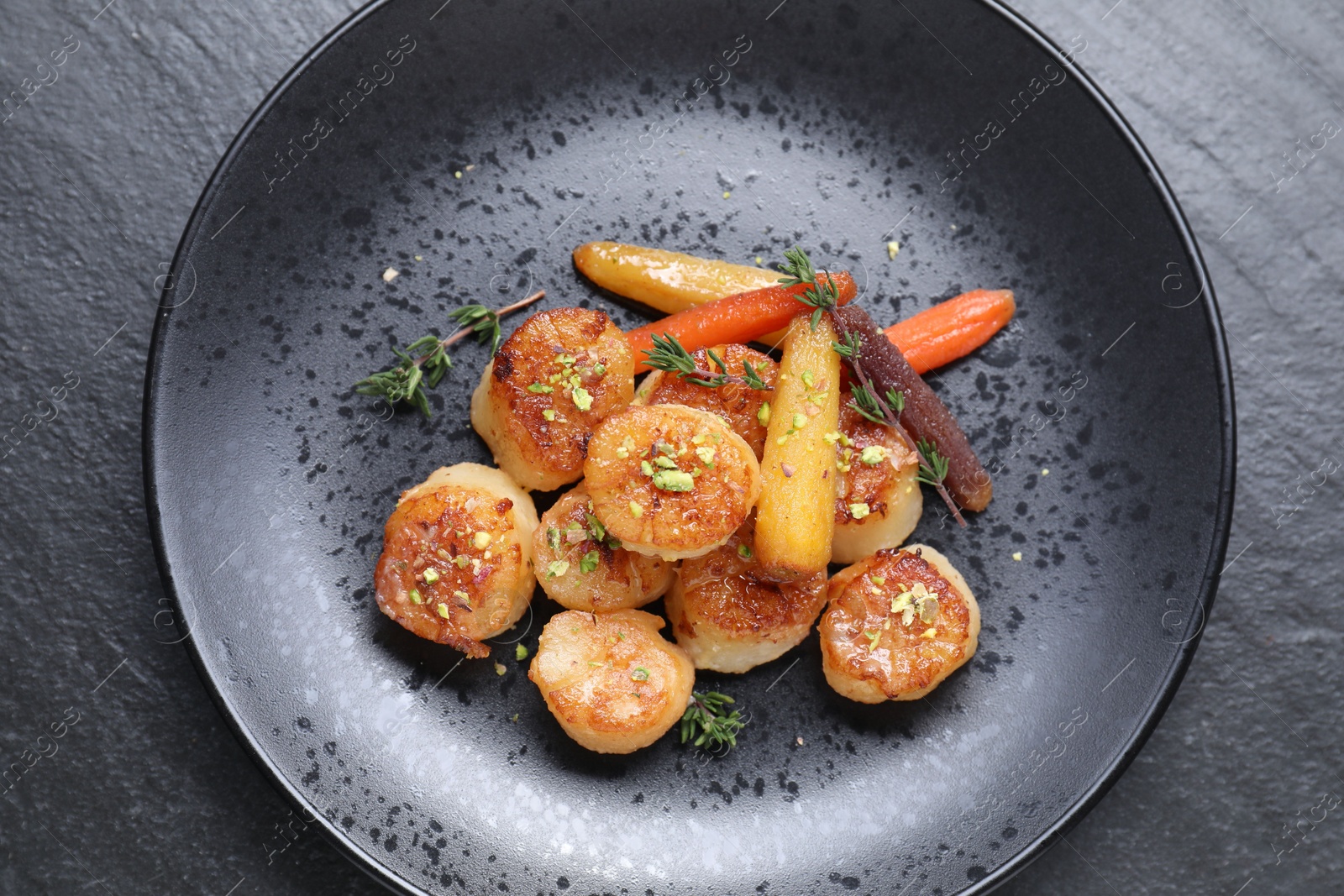 Photo of Delicious fried scallops on dark gray textured table, top view