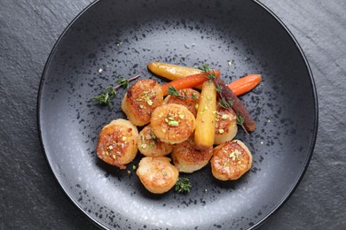 Photo of Delicious fried scallops on dark gray textured table, top view