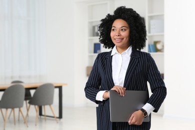 Photo of Smiling young businesswoman with laptop in office. Space for text