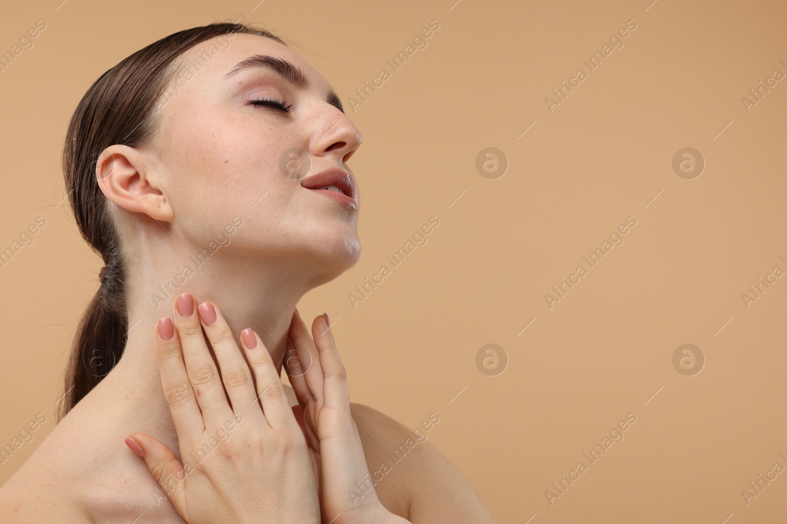 Photo of Beautiful woman touching her neck on beige background. Space for text