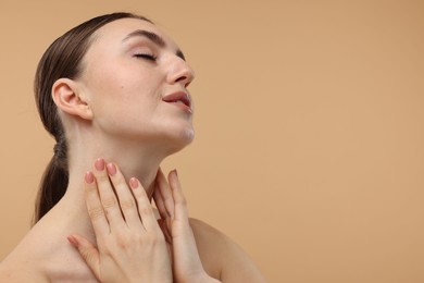 Photo of Beautiful woman touching her neck on beige background. Space for text