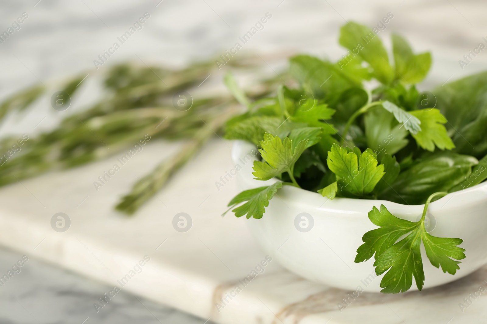 Photo of Bowl with fresh herbs on table, closeup