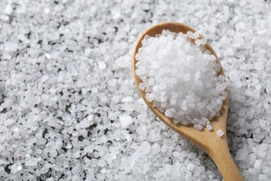 Photo of Natural salt and wooden spoon, closeup view