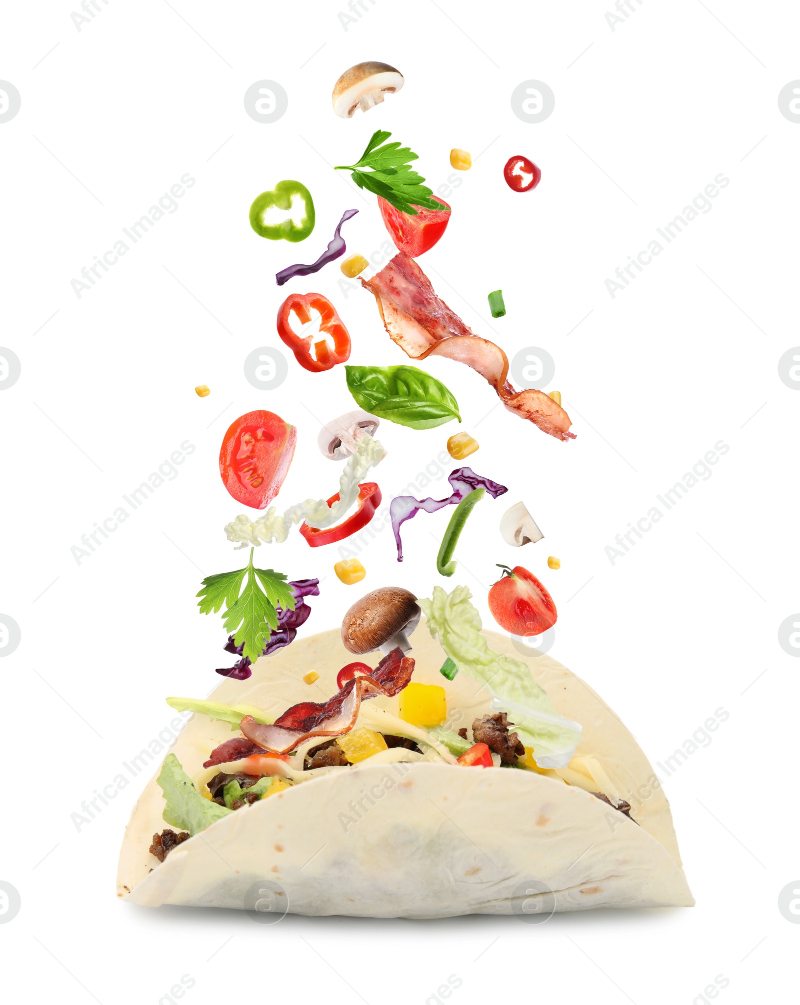 Image of Delicious tacos. Ingredients falling into tortilla on white background