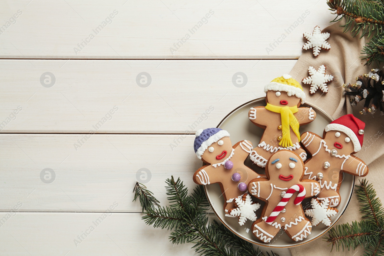 Photo of Delicious Christmas cookies and fir branches on white wooden table, flat lay. Space for text