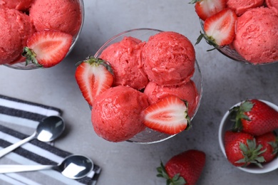 Photo of Delicious strawberry ice cream served on grey table, flat lay