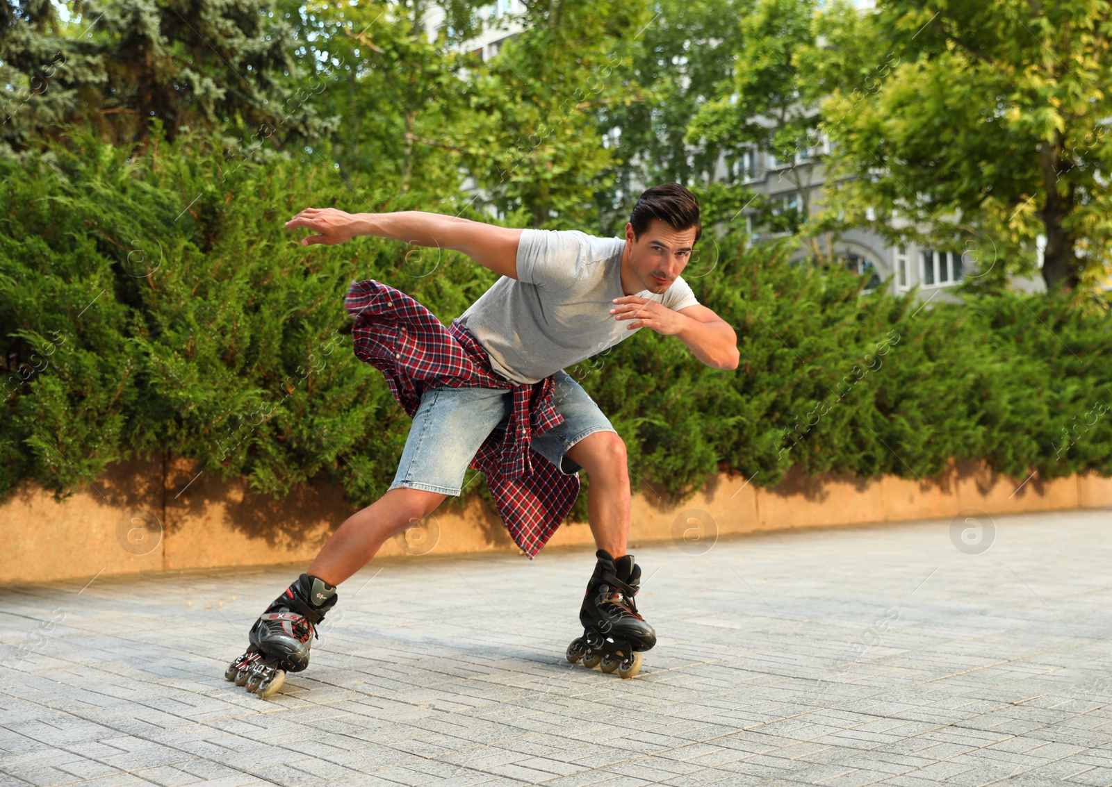 Photo of Handsome young man roller skating outdoors. Recreational activity