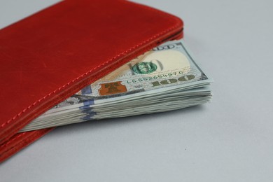 Photo of Money exchange. Wallet with dollar banknotes on gray background, closeup