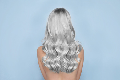 Image of Woman with gray hair on light background, back view