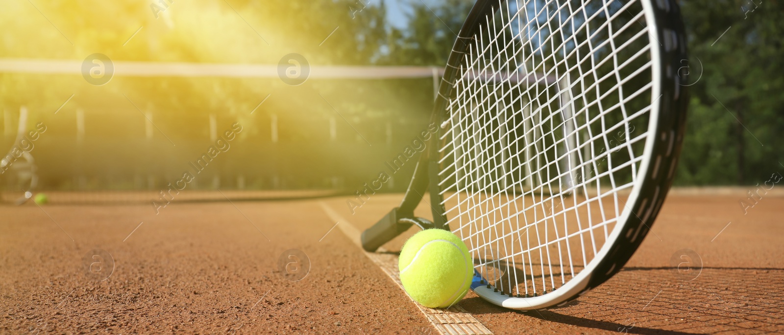 Image of Tennis ball and racket on clay court, space for text. Banner design