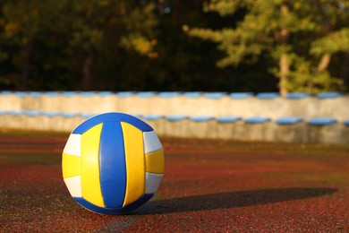 Photo of View of colorful ball on volleyball court outdoors