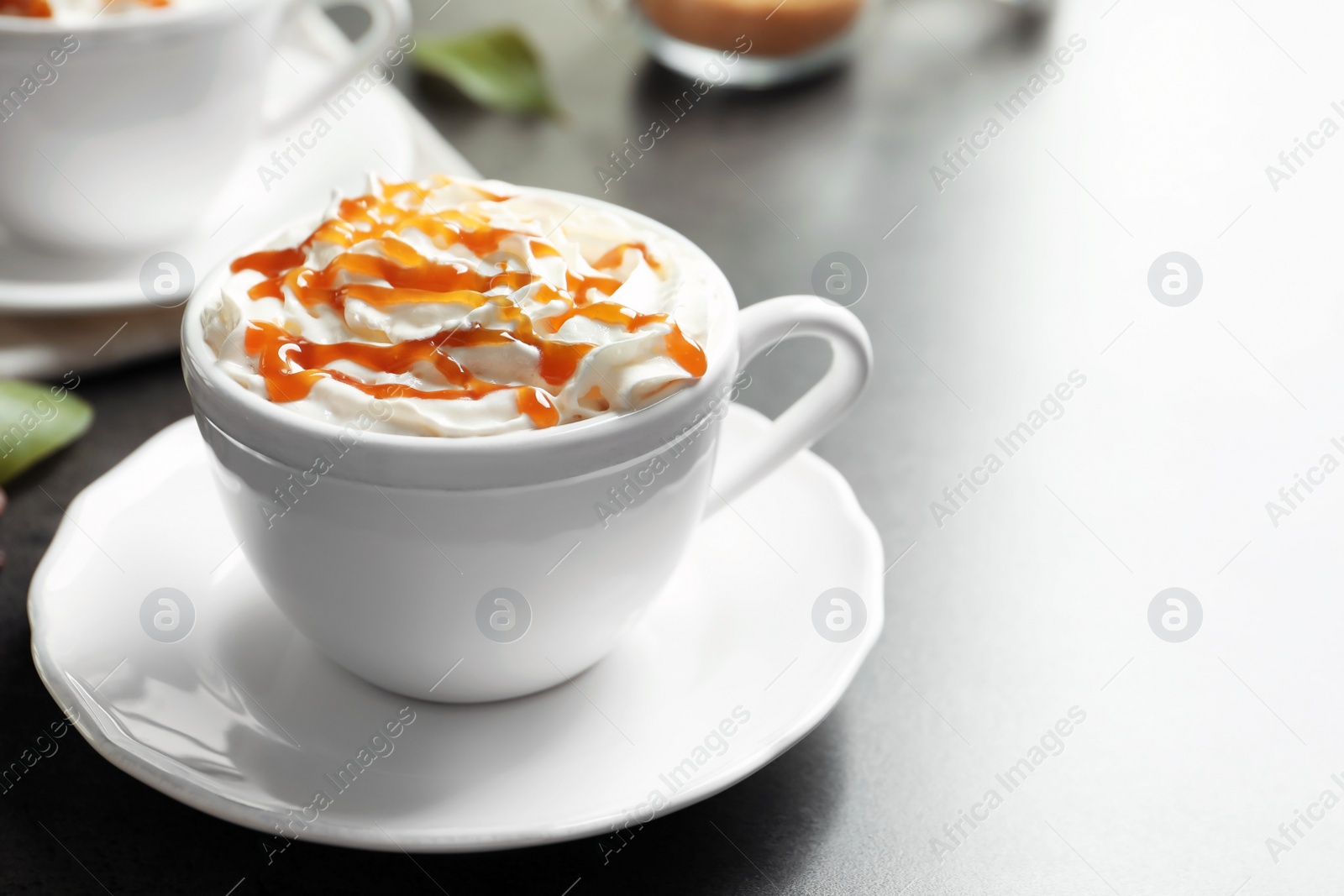 Photo of Cup of coffee with caramel topping on table