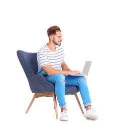 Photo of Handsome young man with laptop in armchair on white background