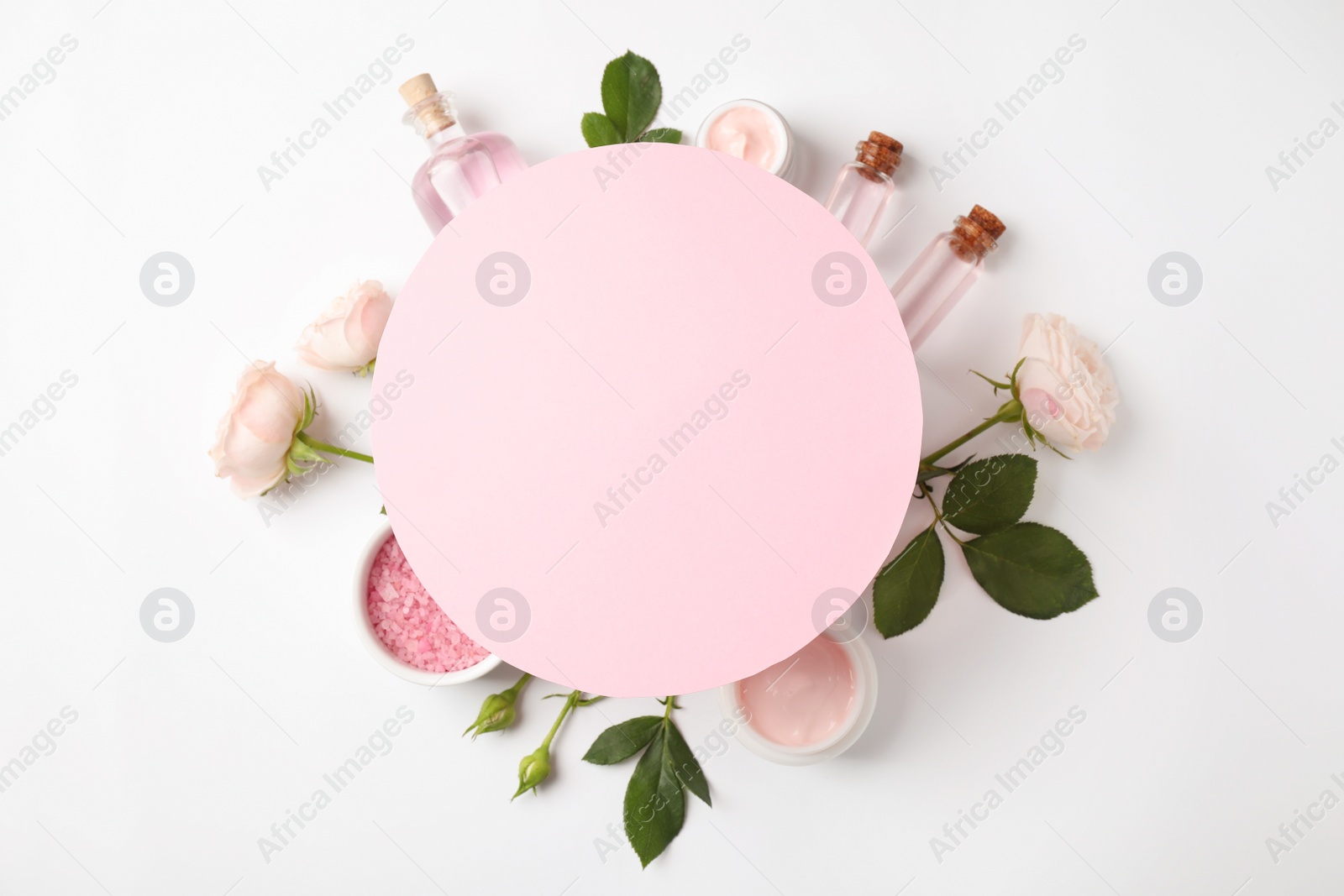 Photo of Composition with rose essential oil and blank card on white background, top view. Space for text