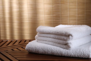 Photo of Stacked soft towels on wooden table indoors