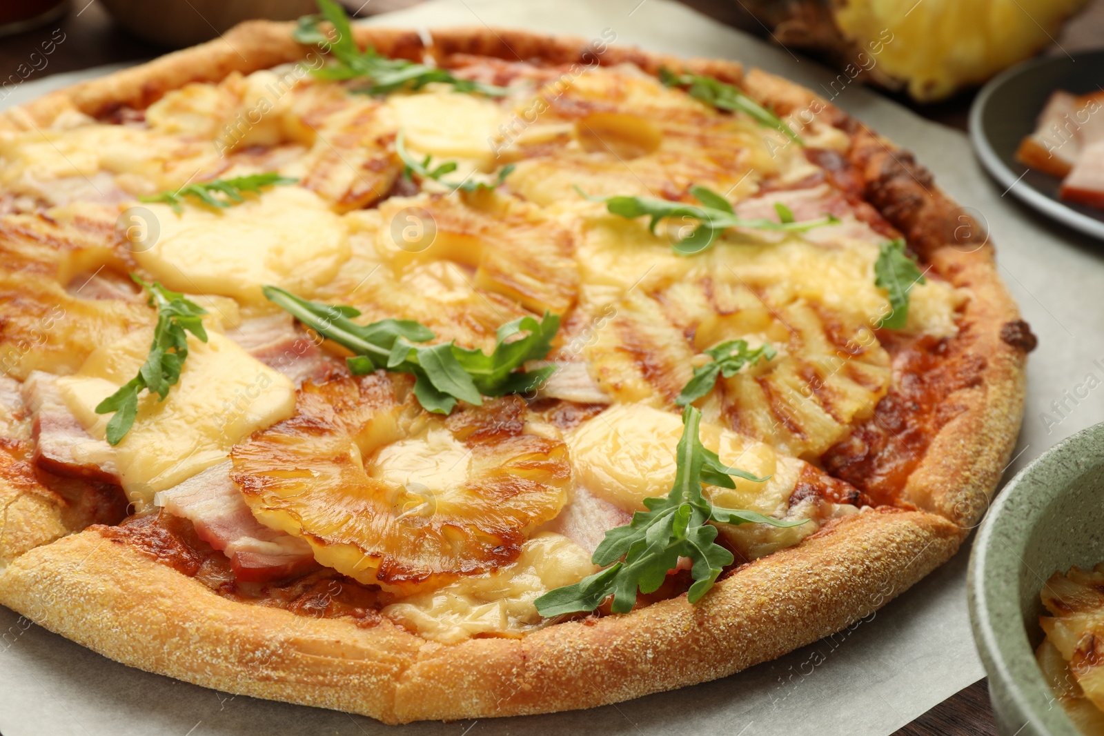 Photo of Delicious pineapple pizza with arugula on table, closeup