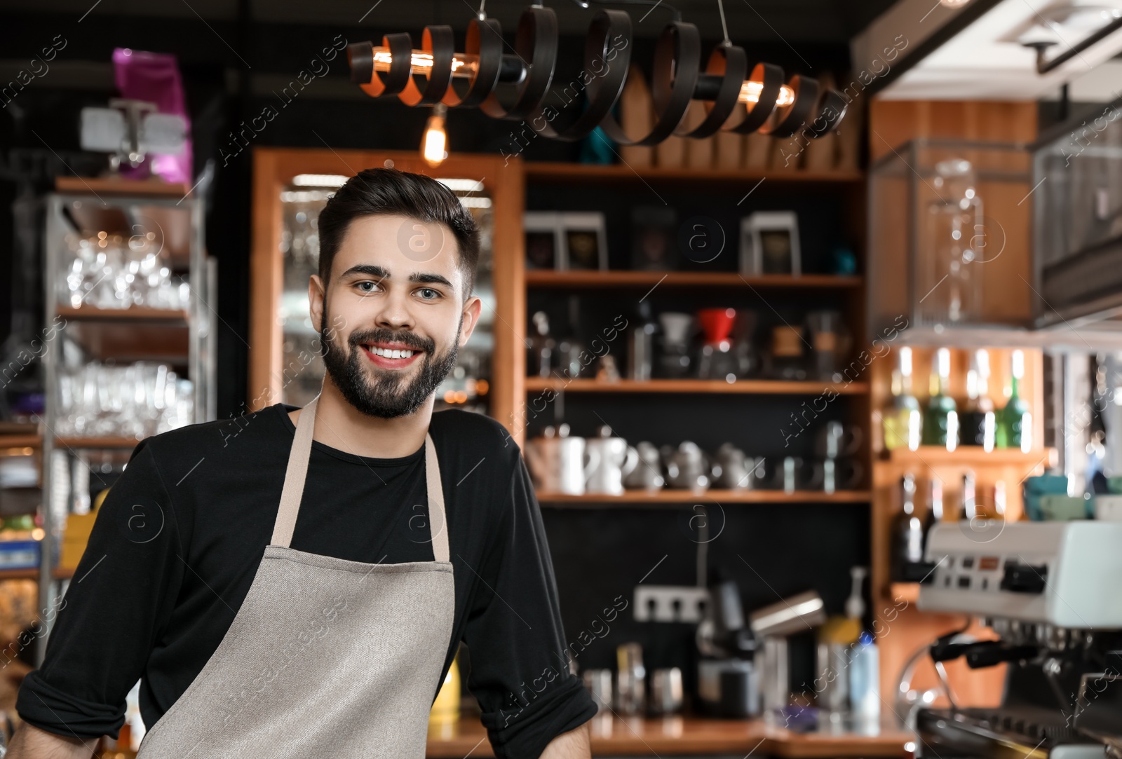 Photo of Portrait of smiling barista in coffee shop. Space for text