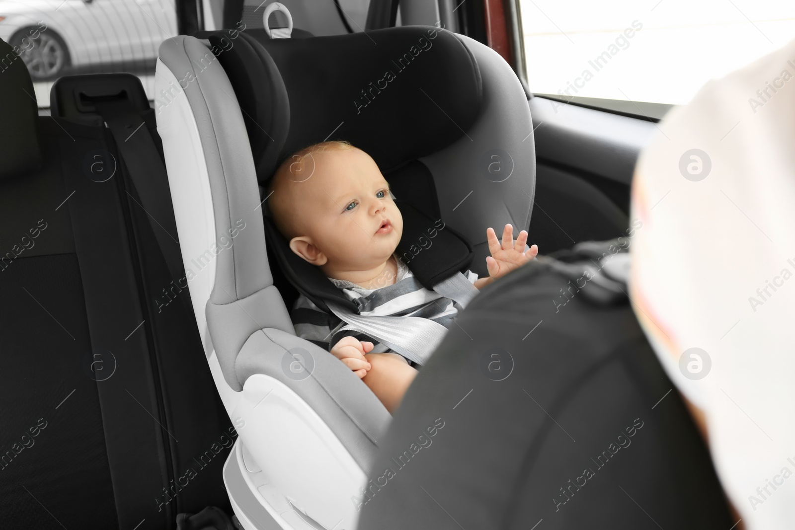 Photo of Little baby in child safety seat inside of car