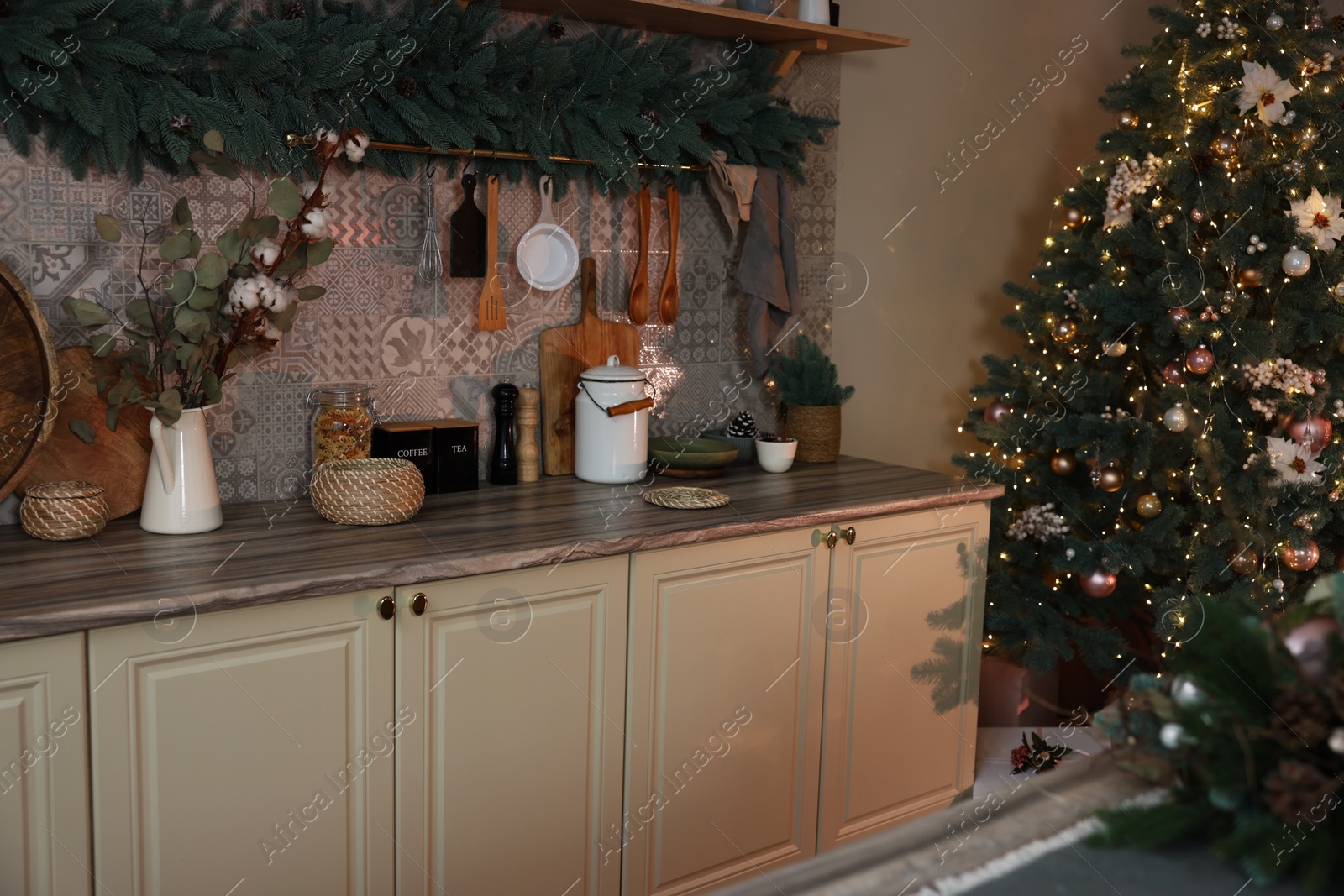 Photo of Stylish kitchen with festive decor and Christmas tree. Interior design