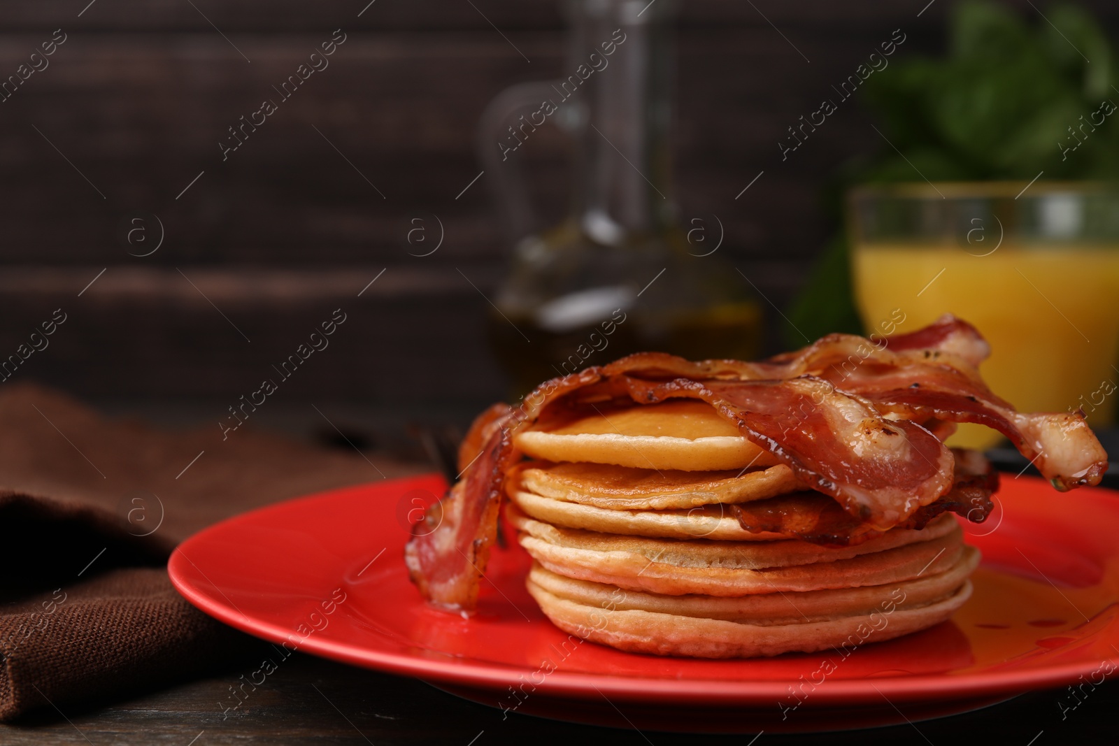 Photo of Delicious pancakes with bacon on table, closeup. Space for text