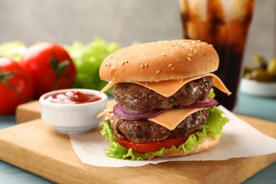 Photo of Tasty hamburger with patties, cheese and vegetables served on table, closeup