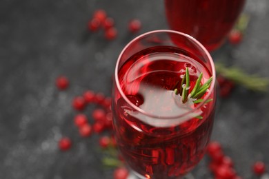 Tasty cranberry cocktail with rosemary in glass on gray table, closeup. Space for text