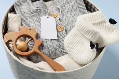 Different baby accessories and clothes in box on light blue background, closeup