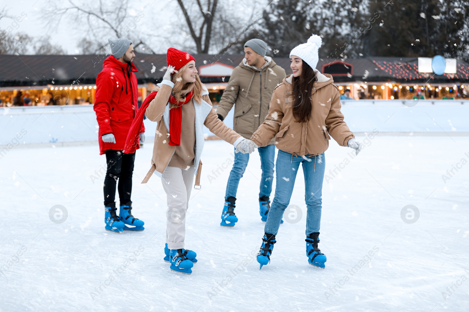 Image of Group of friends skating at outdoor ice rink