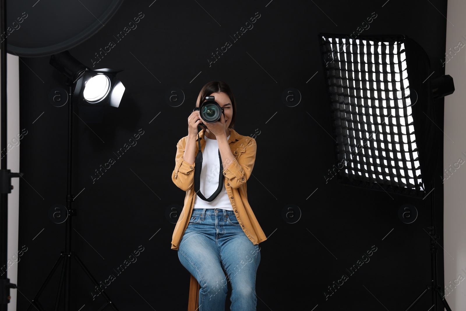 Photo of Professional photographer taking picture in modern photo studio