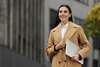 Photo of Smiling woman with laptop outdoors, space for text. Lawyer, businesswoman, accountant or manager